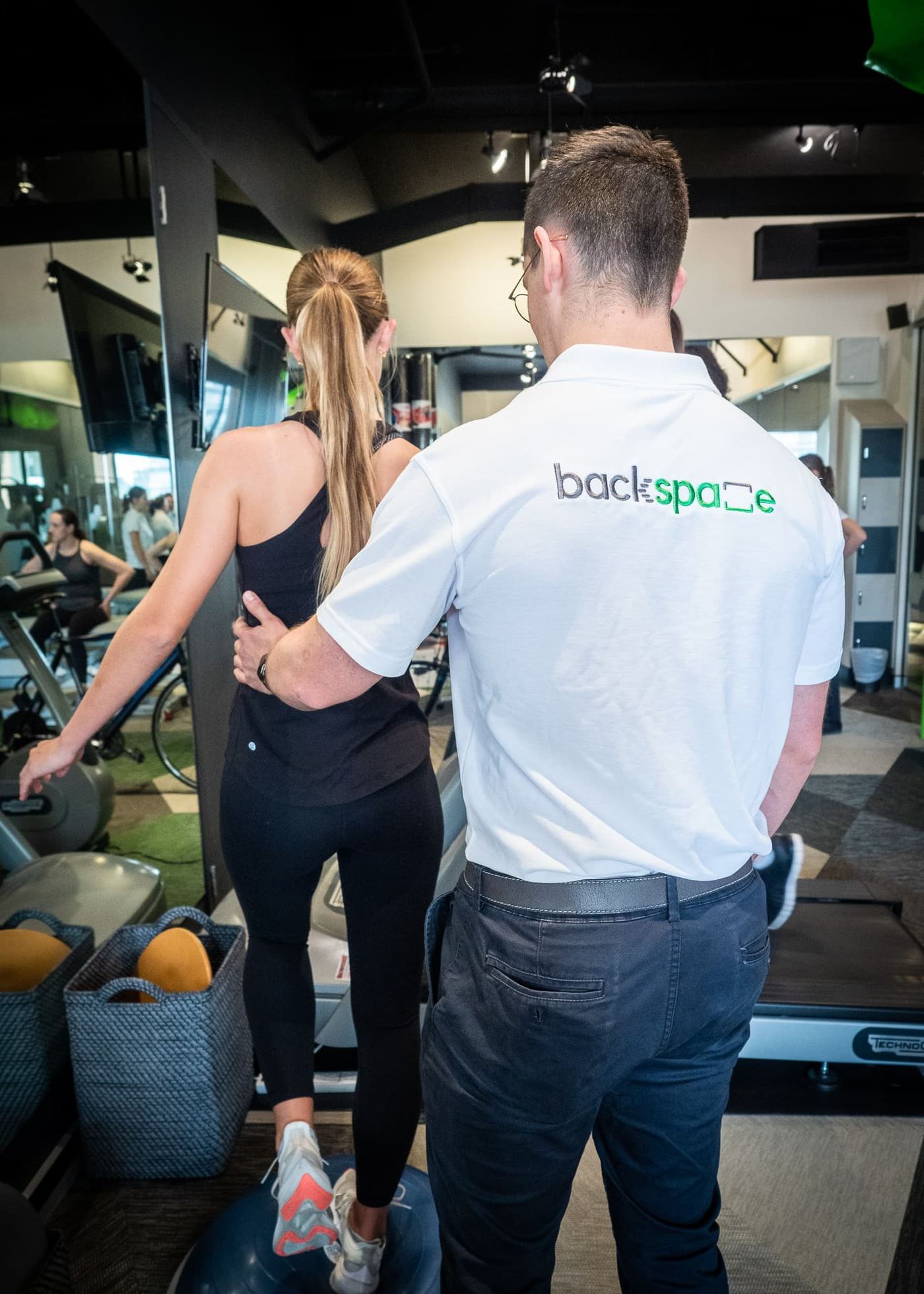 A physiotherapist guiding a patient through rehabilitation in the gym